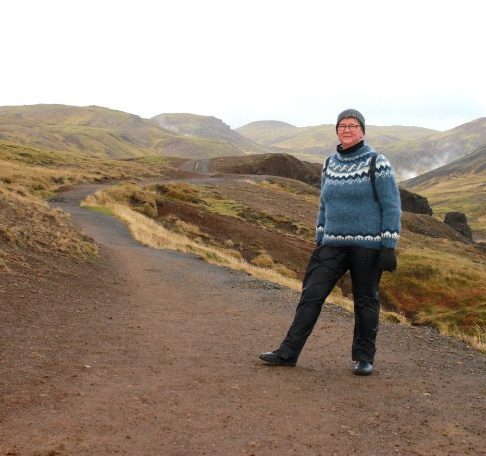 Polku, jonka vieressä naishenkilö ulkovaatteissa.